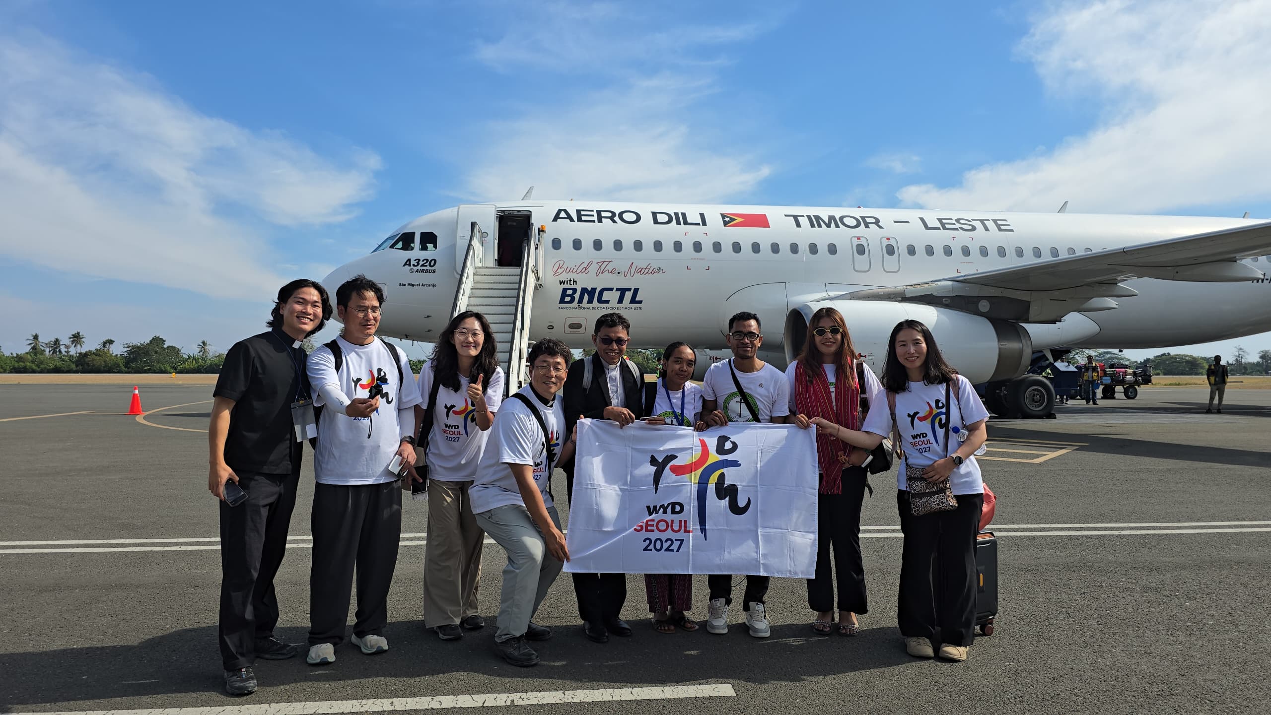 Pilgrims hold the WYD Seoul 2027 flag at the Presidente Nicolau Lobato International Airport (DIL) in Dili, Timor-Leste, on Aug. 23, 2025. | Credit: WYD Seoul 2027 Local Organizing Committee.