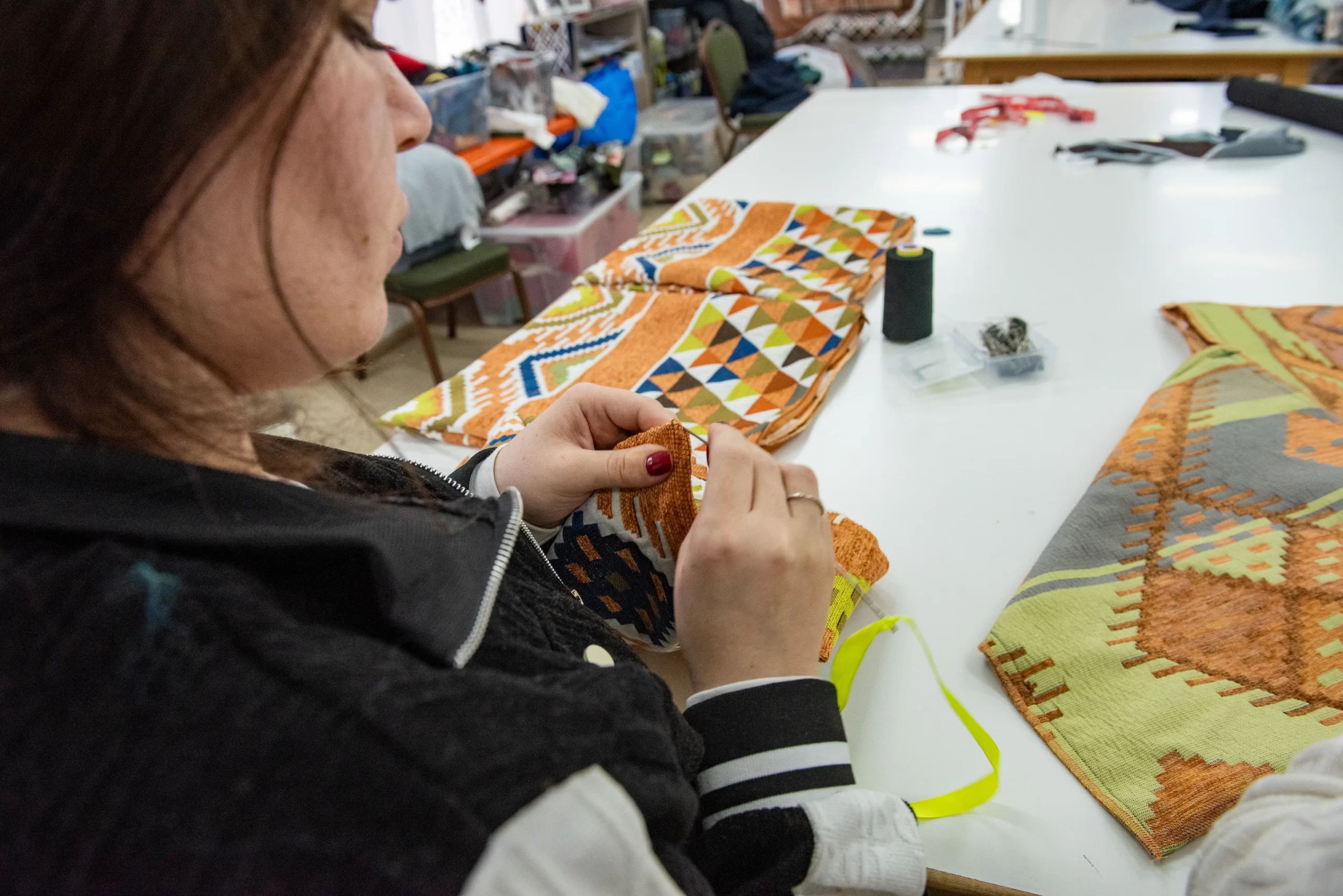 A woman inserts the zipper into a pillowcase lining in the Rafedìn workshop in Amman (Jordan). “We cover expenses and manage to provide a small salary to the girls,” Father Mario Cornioli said. Credit: Marinella Bandini