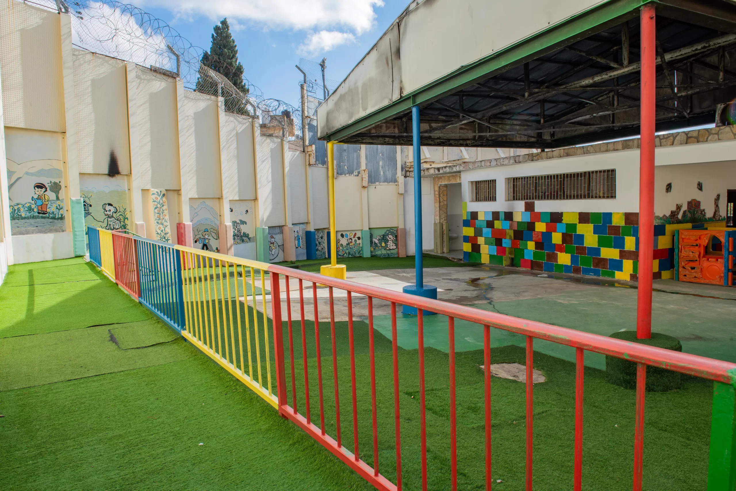 The exterior of the kindergarten, housed on the Comboni Sisters' property. In the background is the separation wall that was  erected on the edge of the Comboni Sisters' property in 2009.