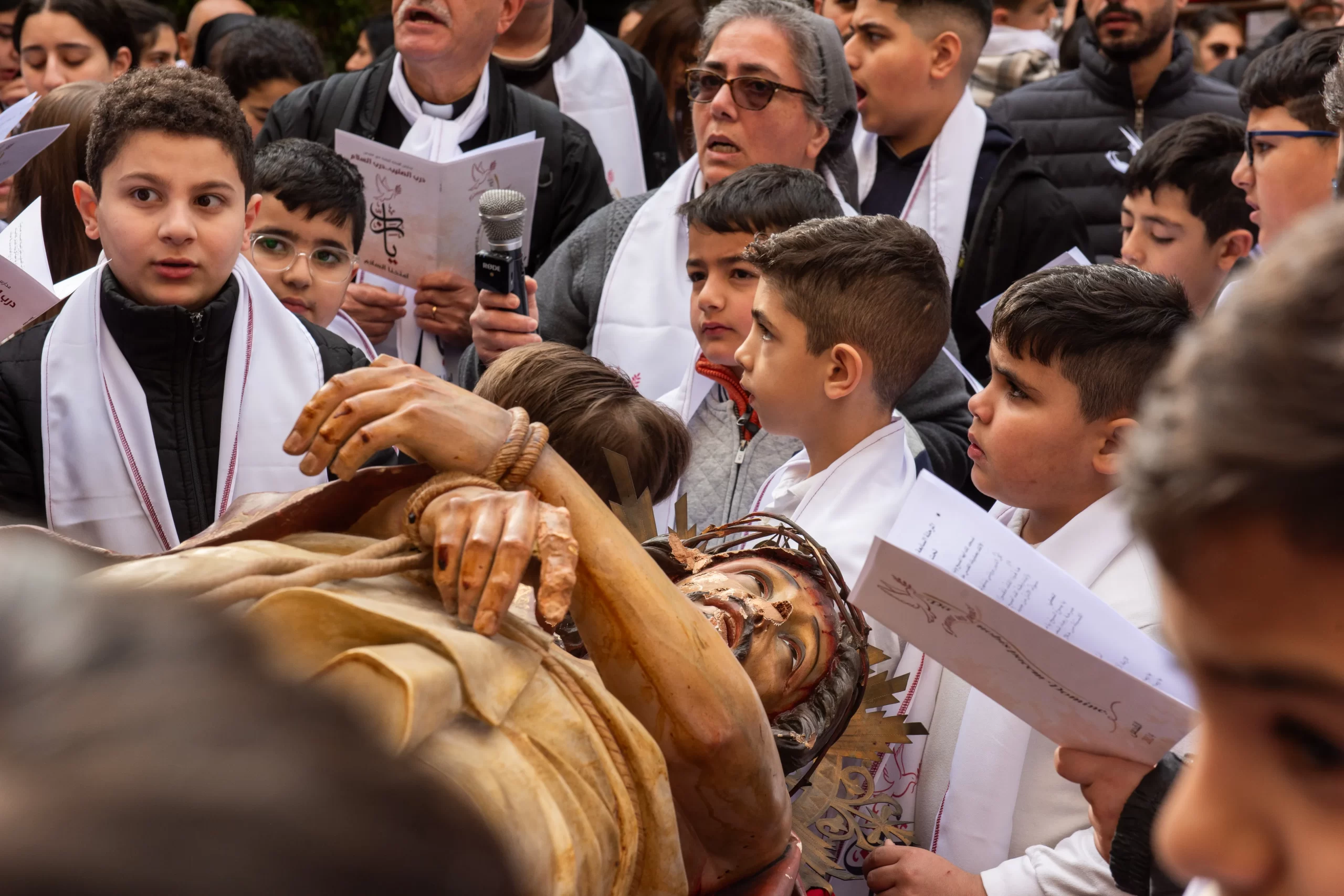 A group of children around the vandalized statue of Jesus at the beginning of the Way of the Cross for Christian school children in Jerusalem organized by the Custody of the Holy Land on Friday, Feb. 23, 2024. Credit: Marinella Bandini