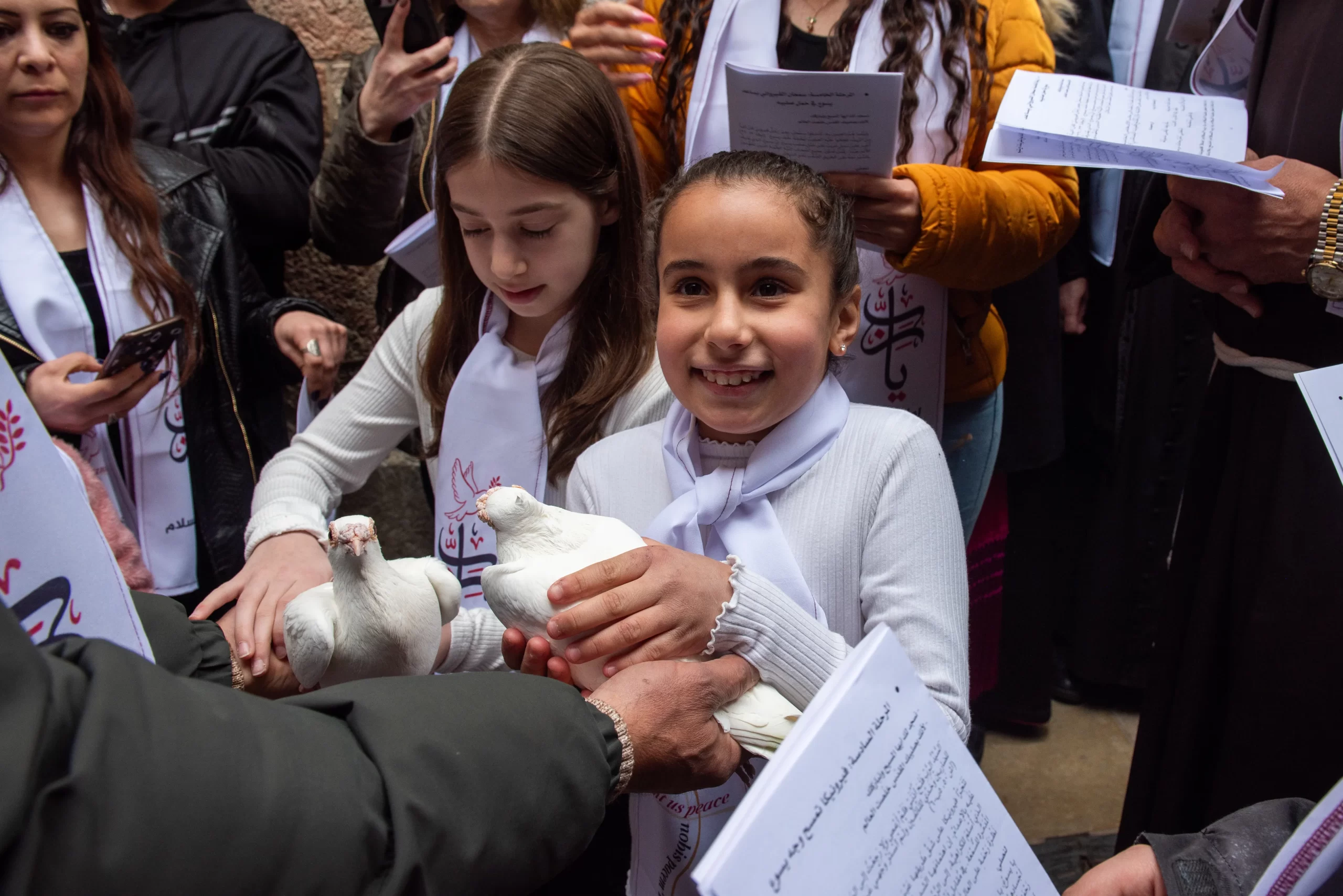 Two children hold doves, which they released moments later, during the Way of the Cross for Christian school students in Jerusalem on Friday, Feb. 23, 2024. The first eight stations took place along the traditional Via Dolorosa route and at each station, after the Scripture reading and prayer, two children released a pair of doves, a visible sign of the prayer for peace and freedom raised by the younger participants. Credit: Marinella Bandini