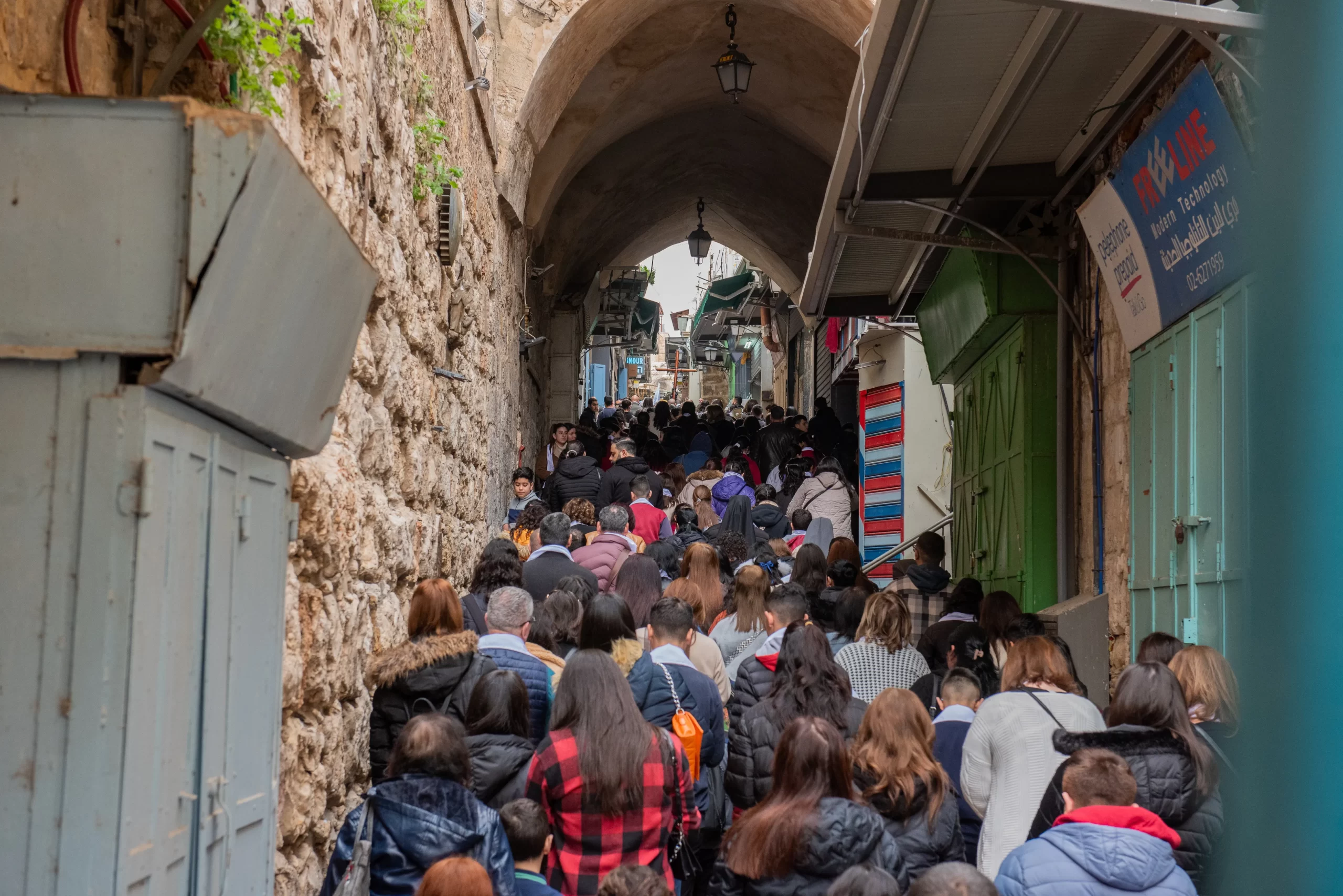 A small crowd of students and professors from Christian schools in Jerusalem took part in  the Way of the Cross organized by the Custody of the Holy Land on Friday, Feb. 23, 2024. The crowd is walking in the street leading to St. Savior's Church after the eighth station of the Via Dolorosa. Credit: Marinella Bandini