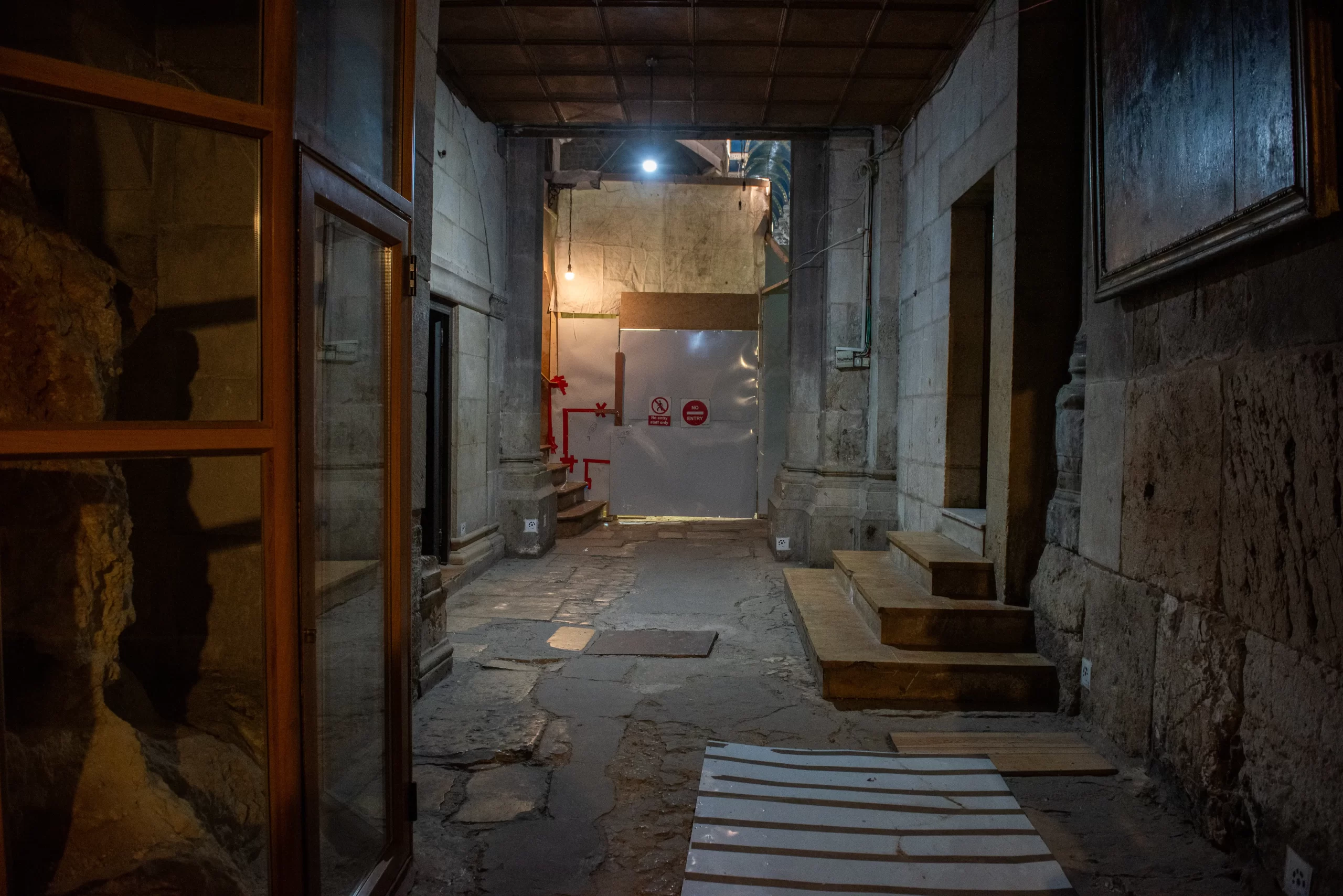 A part of the deambulatory of the Basilica of the Holy Sepulcher (the corridor that goes all around) during floor restoration work. In the background, a panel closes the entrance to the area affected by the work. Credit: Marinella Bandini