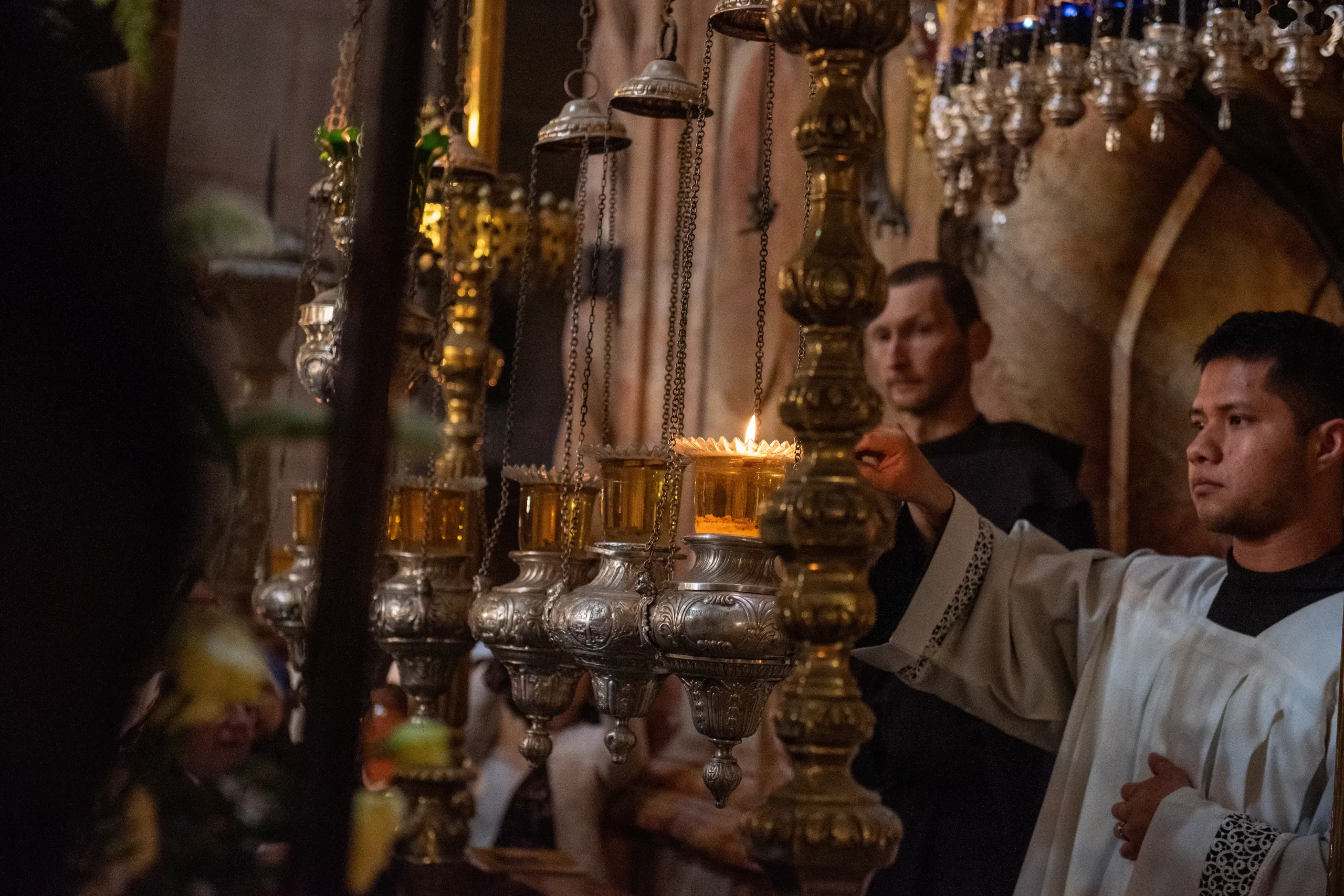 One of the masters of ceremonies lights the lamps in front of the edicule of the Holy Sepulcher during the Easter Vigil, which was held on the morning of Saturday, March 30, 2024, in the Basilica of the Holy Sepulcher, in Jerusalem, in the very place were the Resurrection occurred. Credit: Marinella Bandini