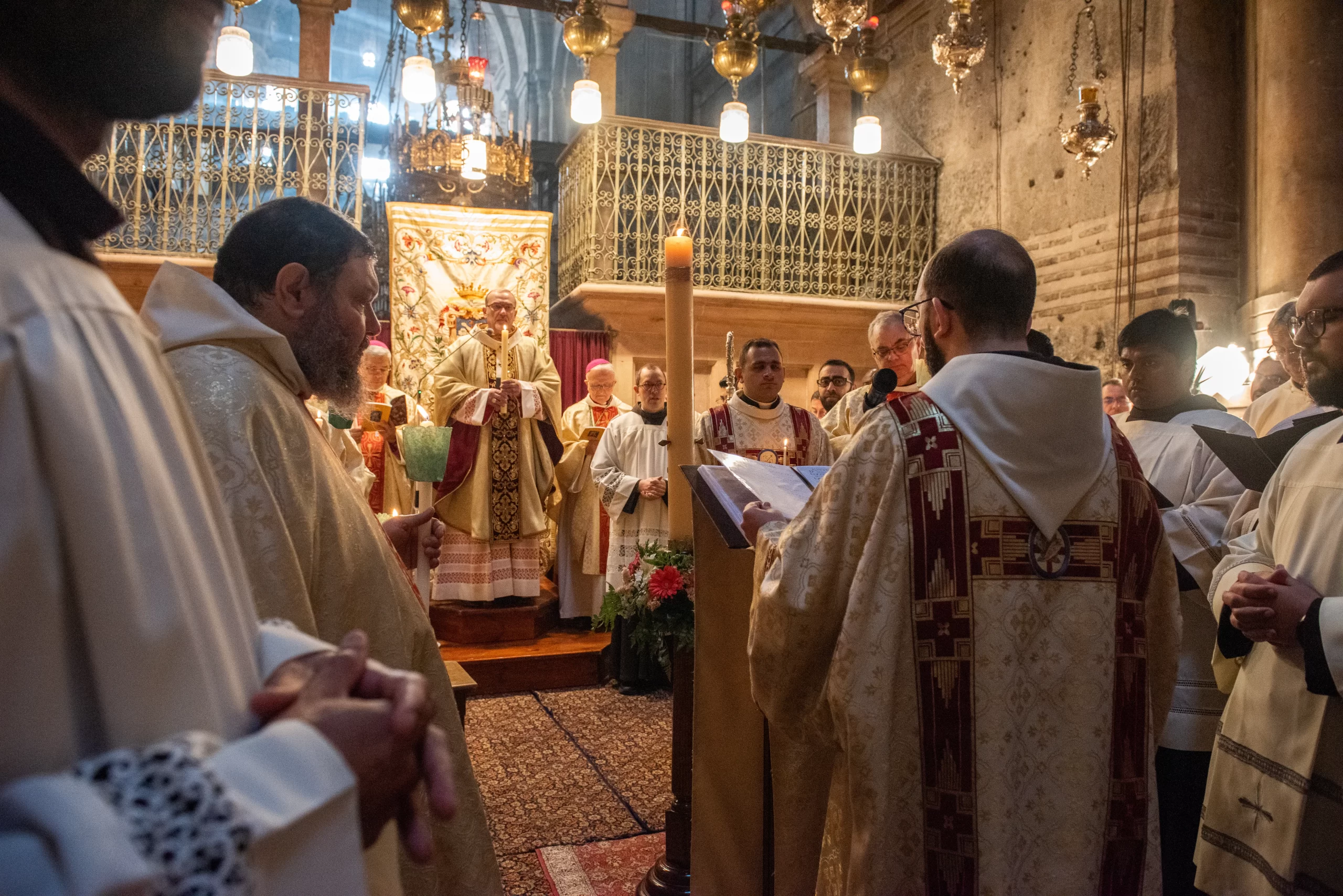 A deacon chants the Easter Proclamation (Exultet) during the Vigil Easter Vigil that was held on the morning of Saturday, March 30, 2024, in the Basilica of the Holy Sepulcher in Jerusalem. This ancient liturgical hymn is a prophecy of Easter. Through it, the victory of light over darkness is proclaimed, and the resurrection of Christ is announced. Credit: Marinella Bandini