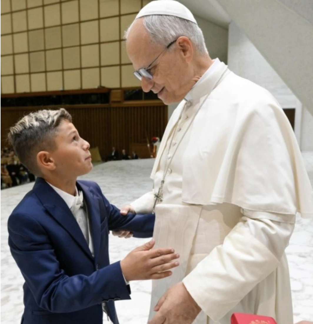 A young boy in the Jubilee of Roma, Sinti, and Travelers gives Pope Leo XIV a hug after asking him a question on Saturday, Oct. 18, 2025. Credit: Vatican Media