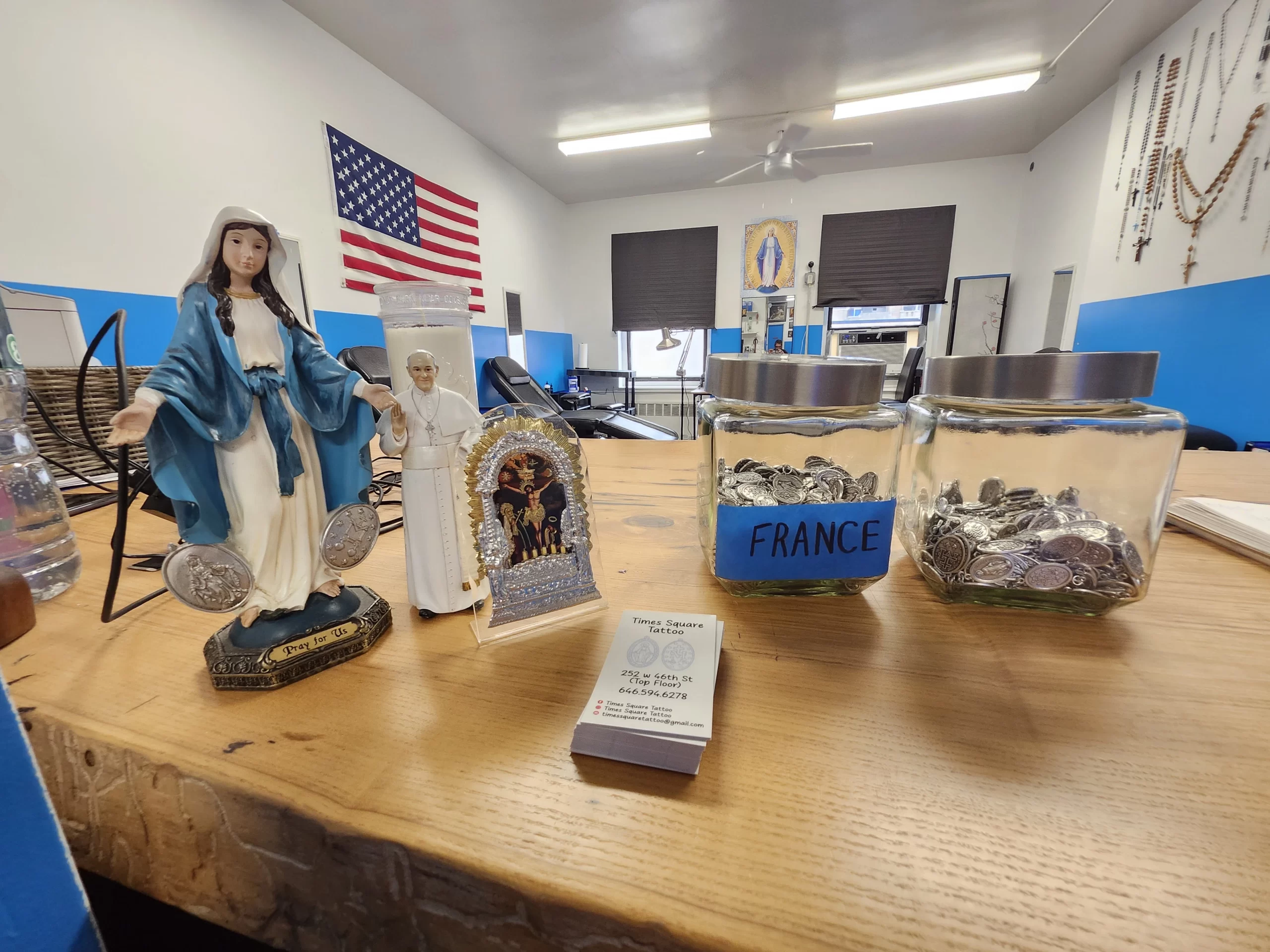 Jars of blessed Miraculous Medals sit on the front desk in Times Square Tattoo. Credit: Photo courtesy of Tommy Houlihan