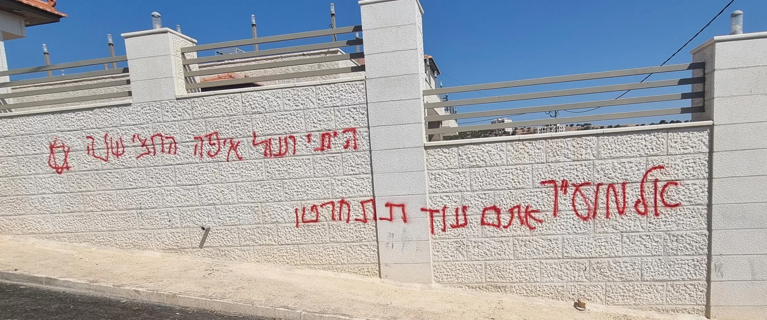 According to eyewitnesses, a group of settlers infiltrated one of the Christian town of Taybeh’s neighborhoods around 2 a.m. on July 28, 2025, set two civilian vehicles on fire, and spray-painted Hebrew graffiti on walls. One message read: “Mughayyir, you will regret it”—a reference to a Palestinian village that was previously targeted in a similar attack. Credit: Photo courtesy of the Palestinian Center