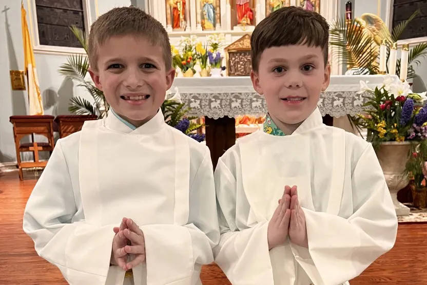 Teddy Howell, right, and a friend serving at the altar at their local parish. Stephani and Sean Howell